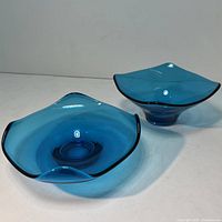Pair of blue Viking glass pieces angled showing shape and rim edge detail.