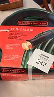Photo of Black & Decker branded garden hose packaged with label showing 50 ft / 15.2 m length, heavy duty designation, and solid aluminum couplings.