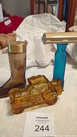 Photo showing all three Avon collector bottles: boot-shaped bottle with gold cap, blue razor-shaped bottle, and amber vintage car-shaped bottle.