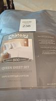 Photo showing the packaging label of Chateau Home Collection Queen sheet set with product details including thread count and materials.