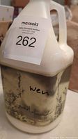 Full view of 1-gallon jug with label and MaxSold auction number visible