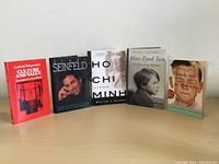 Five books arranged standing on a flat surface, front covers visible, titles and authors readable.