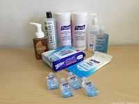 Photo of assorted hand sanitizers and alcohol wipes on a wooden surface.