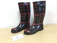 Side view of a pair of plaid rubber boots showing the pattern and shape
