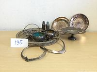 Overview of the silver serving dishes and tray set including tray, plates, bowls, and salt & pepper shakers shown from front perspective on table.