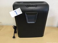 Front view of the black Staples shredder showing the main unit and power cord.