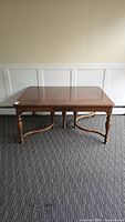 Front view of the antique mahogany dining table showing the turned legs and rectangular tabletop.