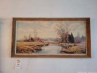 Full front view of the framed art print showing landscape with river and trees.