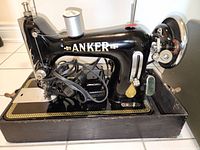 Side view of Anker black vintage sewing machine showing model name and power cord details.
