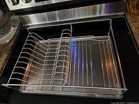 Top view of stainless steel dish drying rack showing dish slots and solid metal base