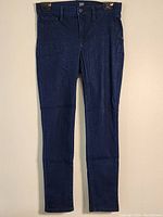 Full front view of the dark envy blue women's skinny fit stretch denim jeans hanging showing the front details including pockets, zipper fly, and waistband with button.