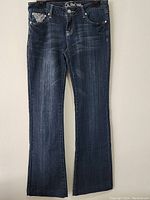 Full front view of L.A.IDOL women's denim pants showing dark blue wash with fading and whiskering, five pocket design, and button closure