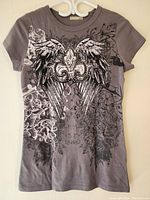Front view of Sirens women's grey top with intricate wing and fleur-de-lis design