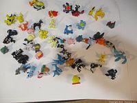 Overview photo showing the full assortment of 48 small Pokemon figures arranged on a white background. Figures include Pikachu, Eevee, Snorlax, and others.