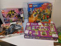Front view of four LEGO boxes including Star Wars, City, Friends, and Ninjago sets laid out together.