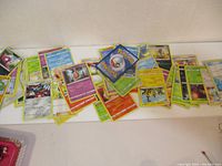 Spread of Pokemon cards laid out face up and some face down showing variety of cards.