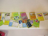 Several Pokémon trading cards spread out, showing different characters and card fronts with yellow borders