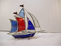 Side view showing details of colored glass panels and metal framework of the stained glass ship sculpture.