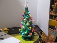 Ceramic Christmas tree lamp with colorful bulbs and star topper, shown lit and unlit