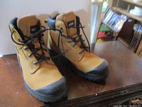 Pair of tan and black steel toed work boots shown at an angle