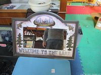 Full view of the embossed mirror with "Welcome to the Lake" text and outdoor-themed decor