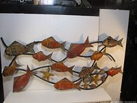 Front view showing entire metal wall art piece with fish and starfish on intertwining branches.