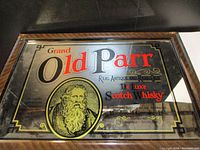 Front view of the vintage Old Parr Scotch Whisky mirror with detailed printed graphics including brand name and portrait.