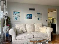 Front view of the cream/beige fabric couch with softly textured cushions and several decorative pillows.