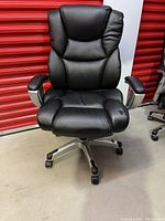 Front view of the black bonded leather office chair showing padded seat and armrests, high backrest, five-star wheel base.