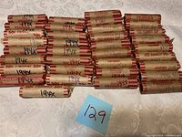 Top-down view of 35 rolls of pennies wrapped in brown paper with 50¢ and 'PENNIES' printed in red, marked with '194x' in ink.