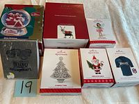 Photo of seven different boxed Christmas ornaments for sale including several Hallmark Keepsake series and other brands.