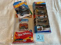 Lot of Hot Wheels cars displayed: a World's Smallest Hot Wheels in blister packaging, a 5-pack 'Exposed Engines' set, and two separate single-pack cars packed in blister cards.