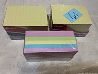 Three packs of self-stick note pads with two packs yellow 12-pad units and one pack pastel 6-pad unit, all unopened