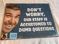 Full view of tin sign showing the printed man's face on the left side and white text on blue background.