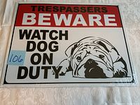 Photo of tin sign showing front side with text and bulldog image.