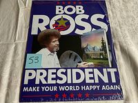 Front view of Bob Ross President tin sign with visible text and image, plastic seal torn on edges.