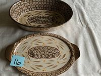 Side by side image of two Temptations ceramic dishes on a white tablecloth, showing flower and leaf patterns in brown and cream.
