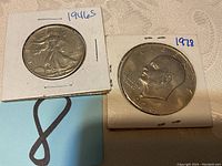 Photo of two coins: 1946 S Walking Liberty half dollar on the left and 1978 Eisenhower dollar on the right, in cardboard holders.