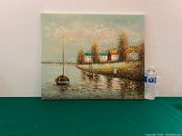 Full view of the oil on canvas painting showing coastal houses and sailboats with a water bottle for scale