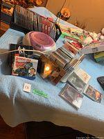 Photo showing portable pink and purple CD player with antenna and multiple CDs in cases and sleeves.