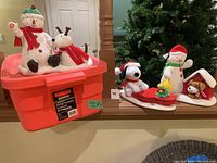 Overall photo of the lot showing 5 Hallmark holiday decorations including snowmen, reindeer, Snoopy on a sled, and a small dog figure.