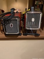 Side-by-side view of two red Honeywell personal heaters showing front grills with chrome trim and logos