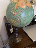 Desk globe showing the Asia and Australia region, mounted on a turned wooden base