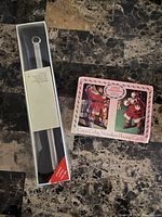 Photo of boxed Star Feuerzeug lighter next to Coca-Cola playing cards box on dark marble surface.