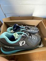 Pair of gray and teal Pearl Izumi women's cycling shoes in original box, size 8.5 visible.