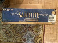 Sony branded cardboard box showing 'Digital Satellite Receiver' text and model illustration on top.