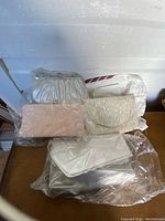 Five vintage purses grouped together showing different styles and textures, some in protective plastic bags.