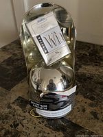 Front and angled view of Winston Quantum Smooth cigarette counter display showing reflective metallic base, curved mirrored backing, and cigarette pack graphic.