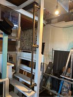 Photo showing the full brass rail mounted vertically on a wooden post with visible tarnish and mounting brackets.