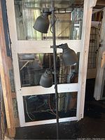 Full view of the grey metal floor lamp with three adjustable shades, showing height and base